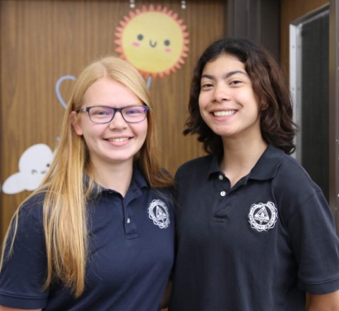 Grace Busch (left) poses with her friend outside her office. 